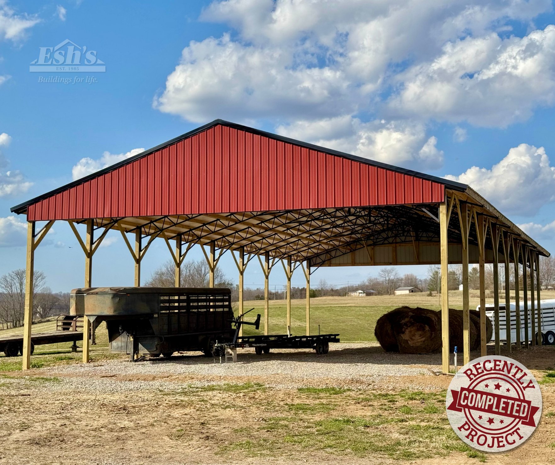 Red open-sided agricultural pole barn