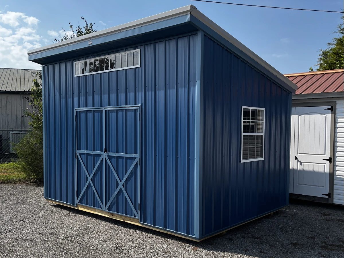 Navy-blue metal shed with a lean-to slant roof, a clerestory window band, and white trim