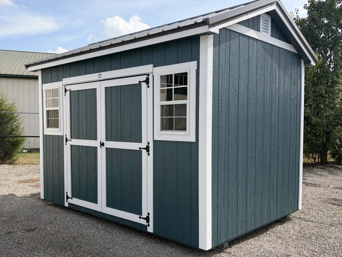 Slate-gray gable shed with white trim, doors, and window frames
