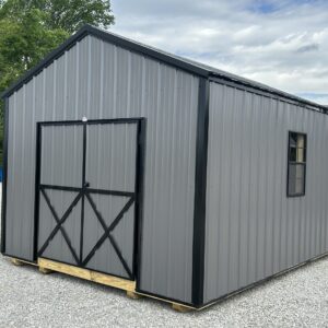 Gray corrugated metal storage shed on wooden supports in a gravel lot, featuring double doors and a small window on the side.